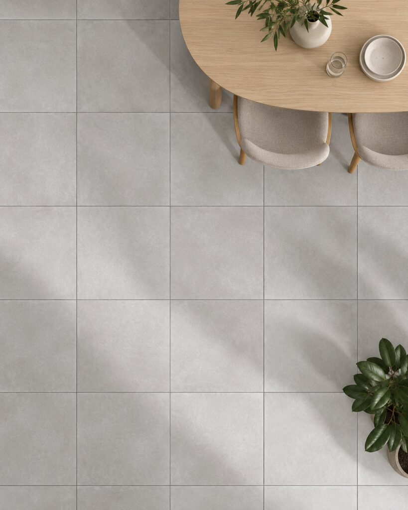Grijze matte vloertegels in een eetruimte met houten tafel