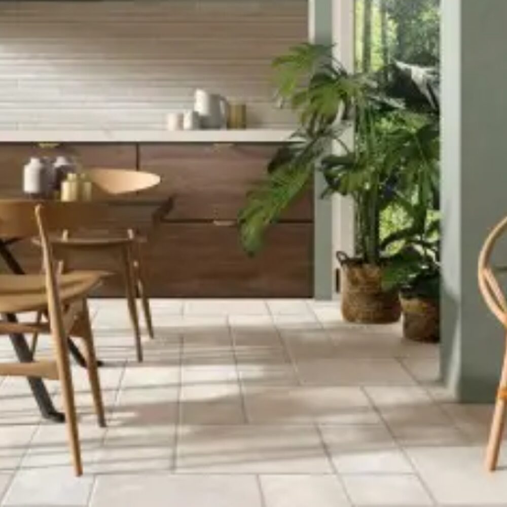 Beige tegelvloer in meerdere formaten in een keuken met houten meubels.