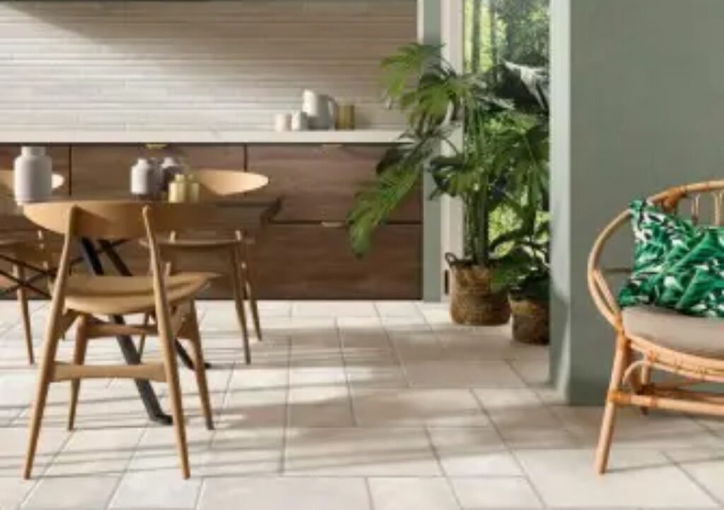 Beige tegelvloer in meerdere formaten in een keuken met houten meubels.