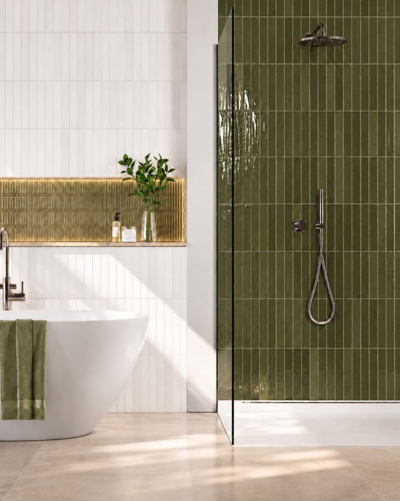 Badkamer met Mindelo Glans Nairobi Green Moss 5x30 wandtegels in de douche en een vrijstaand wit bad